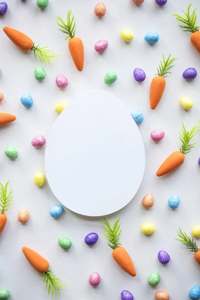 Pasen seizoensgebonden achtergrond met kleurrijke eieren en worteltjes — Stockfoto