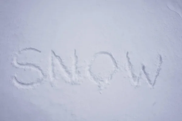 Palabra de nieve escrita en un fondo de nieve fría — Foto de Stock