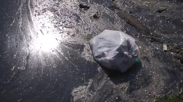 Kunststofafval dat in de natuur vervuilt. vuilnis zak drijvend op water — Stockvideo