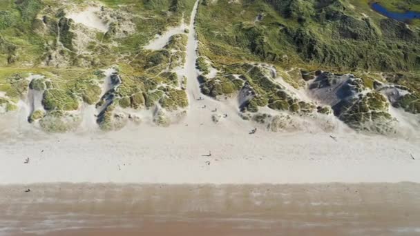Εναέρια θέα καθώς οι άνθρωποι περπατούν μέσα από αμμόλοφους στην παραλία Harlech, Βόρεια Ουαλία — Αρχείο Βίντεο