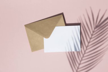 Boş beyaz kart ve kahverengi kağıt zarf üzerinde Yaz palmiye yaprağı gölge kadar mock