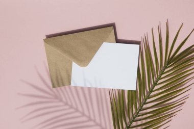 Boş beyaz kart ve kahverengi kağıt zarf üzerinde Yaz palmiye yaprağı gölge kadar mock