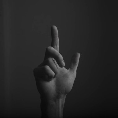 Erkek el, koyu bir arka plana parmağını gösteriyor. Seçme, dokunma