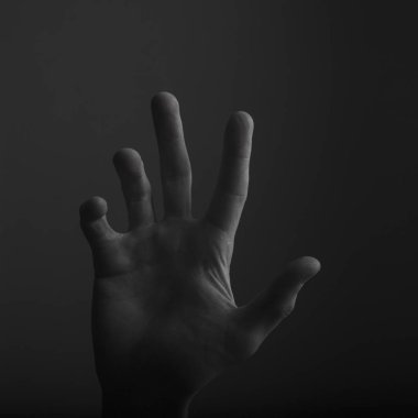 Koyu bir arka plan üzerinde erkek açık el hareketi