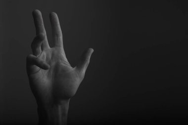 Koyu bir arka plan üzerinde erkek açık el hareketi