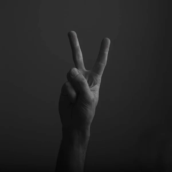 Erkek el karanlık bir arka plan karşı zafer V el işareti gösteren — Stok fotoğraf