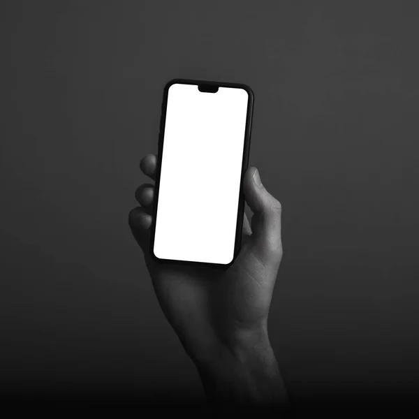 Mano sosteniendo teléfono inteligente moderno con una pantalla blanca en blanco — Foto de Stock