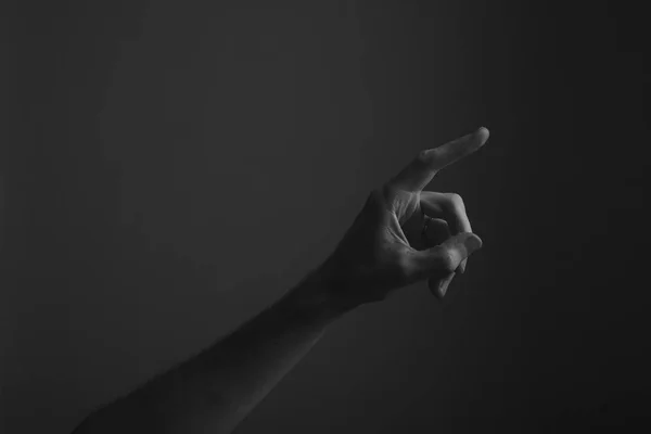 Manlig hand som pekar ett finger mot en mörk bakgrund. Välja, trycka på — Stockfoto