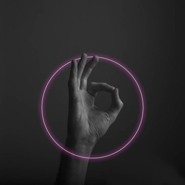 Soyut neon ışık parıltısı ile tamam bir el hareketi kapatın. Tamam el işareti