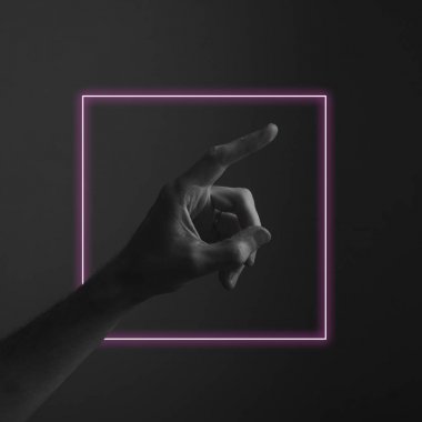 Soyut neon ışık parıltısı ile karanlık bir arka plana parmak doğrultan el