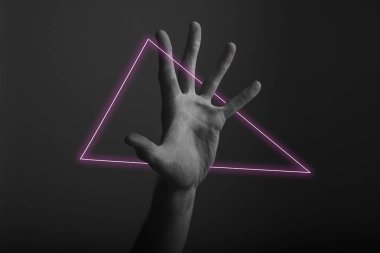 Soyut neon ışık parıltısı ile karanlık bir arka plan üzerinde erkek açık el hareketi