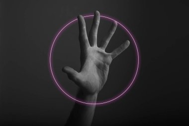 Soyut neon ışık parıltısı ile karanlık bir arka plan üzerinde erkek açık el hareketi