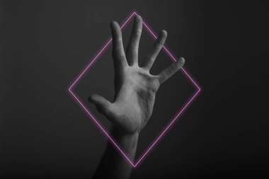 Soyut neon ışık parıltısı ile karanlık bir arka plan üzerinde erkek açık el hareketi