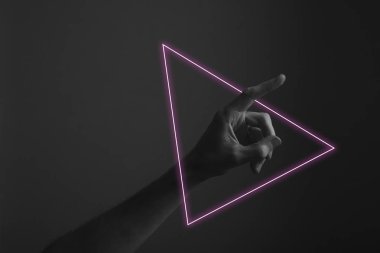 Soyut neon ışık parıltısı ile karanlık bir arka plana parmak doğrultan el