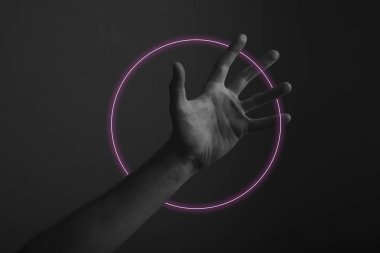 Soyut neon ışık parıltısı ile karanlık bir arka plan üzerinde erkek açık el hareketi