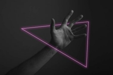 Soyut neon ışık parıltısı ile karanlık bir arka plan üzerinde erkek açık el hareketi