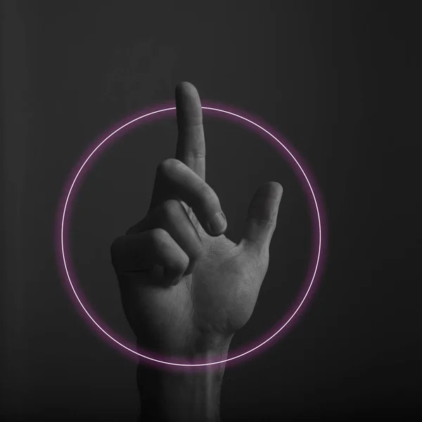 Mão apontando um dedo contra um fundo escuro com brilho claro de néon abstrato — Fotografia de Stock