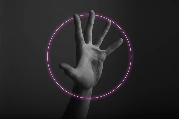 Gesto de mano abierta masculina sobre un fondo oscuro con resplandor de luz de neón abstracto — Foto de Stock