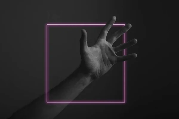 Mannelijk open hand gebaar op een donkere achtergrond met abstracte Neon lichte gloed — Stockfoto