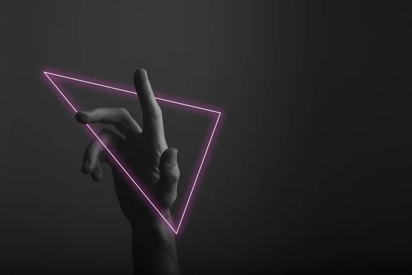 Hand wijzend een vinger tegen een donkere achtergrond met abstracte Neon lichtgloed — Stockfoto