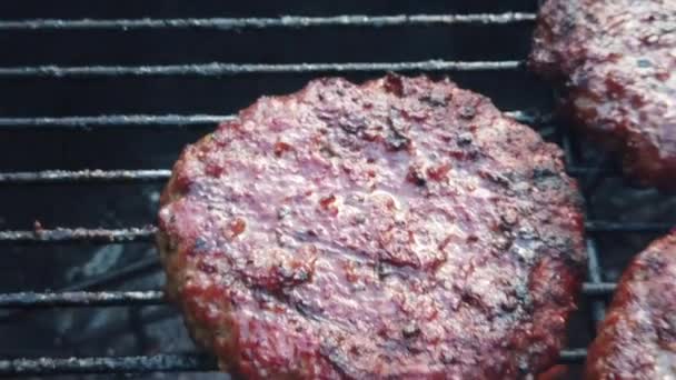 Zeitlupe von Bio-Burgern, die auf einem Grill umgedreht werden — Stockvideo