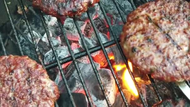 Zeitlupe von Bio-Burgern, die auf einem Grill umgedreht werden — Stockvideo