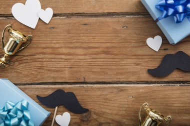 Babalar günü kompozisyonu. Ahşap arka plan üzerinde kalpleri ve bıyık ile Hediye kutusu