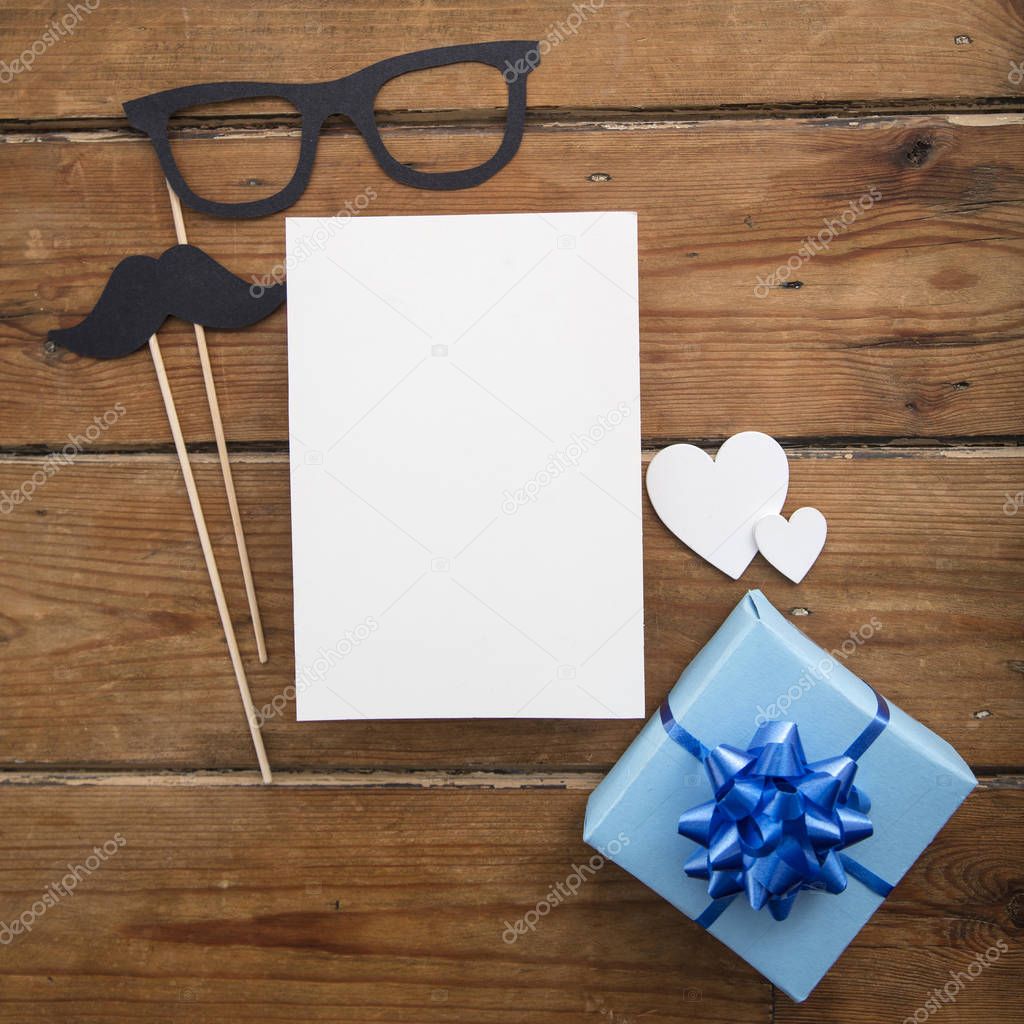Fathers day blank card with blue wrapped present and paper mustache