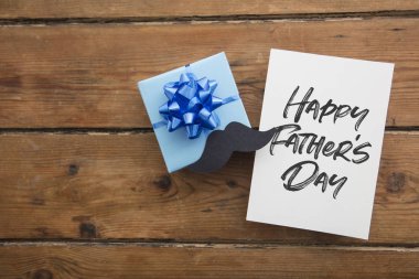 Hediye kutusu ve bıyık ile Happy Babalar Günü kart kompozisyonu