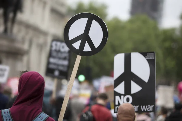 A person holds a peace sign banner at a protest — Stock Photo, Image