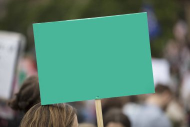 Siyasi bir mitingde boş yeşil protesto pankartı tutan bir kişi