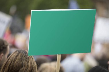 Siyasi bir mitingde boş yeşil protesto pankartı tutan bir kişi