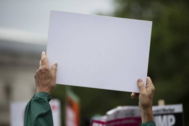 Siyasi bir mitingde boş bir protesto pankartı tutan bir kişi