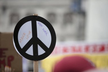 Bir kişi bir protesto bir barış işareti afiş tutar