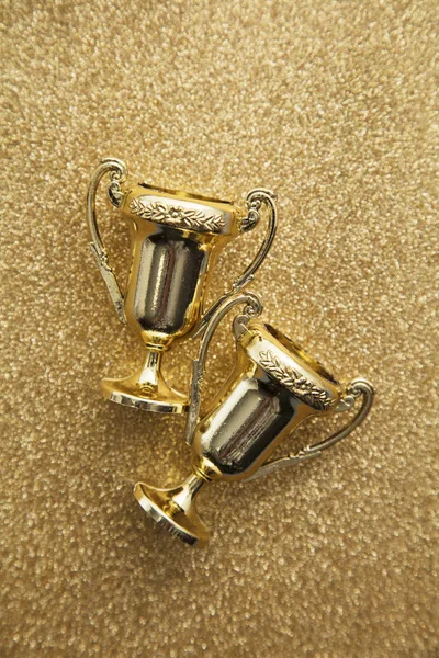 Gold winners achievement trophy on a gold glitter background — Stock Photo, Image