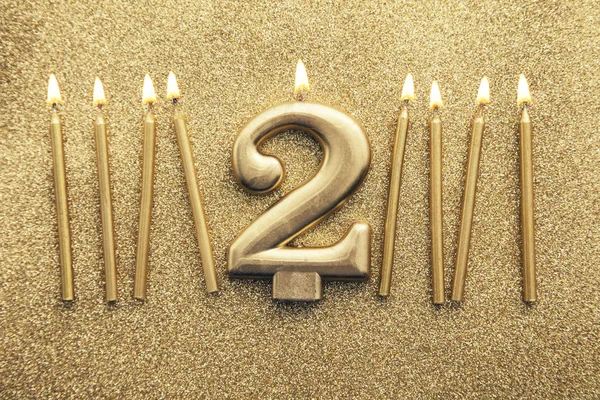 Золотая свеча для празднования 2-го числа на блестящем фоне — стоковое фото