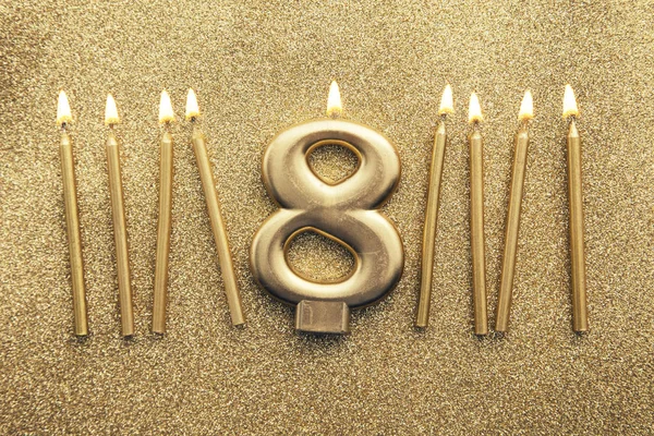 Numer 8 złota celebracja świecy na tle brokatu — Zdjęcie stockowe