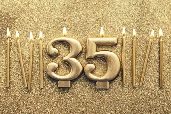 Número 35 vela de celebración de oro sobre un fondo de brillo —  Fotos de Stock
