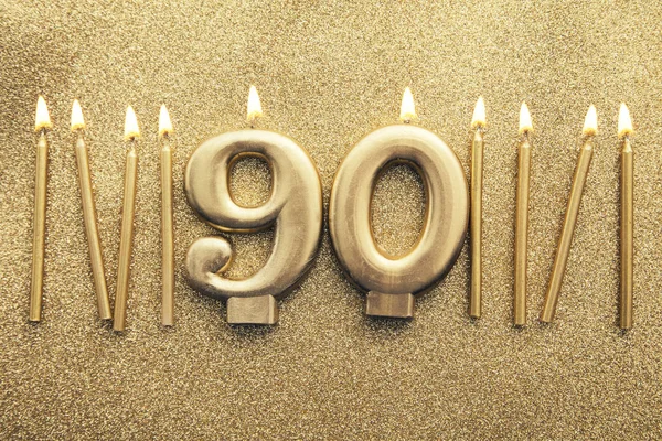 Vela de celebración dorada número 90 sobre fondo brillante — Foto de Stock