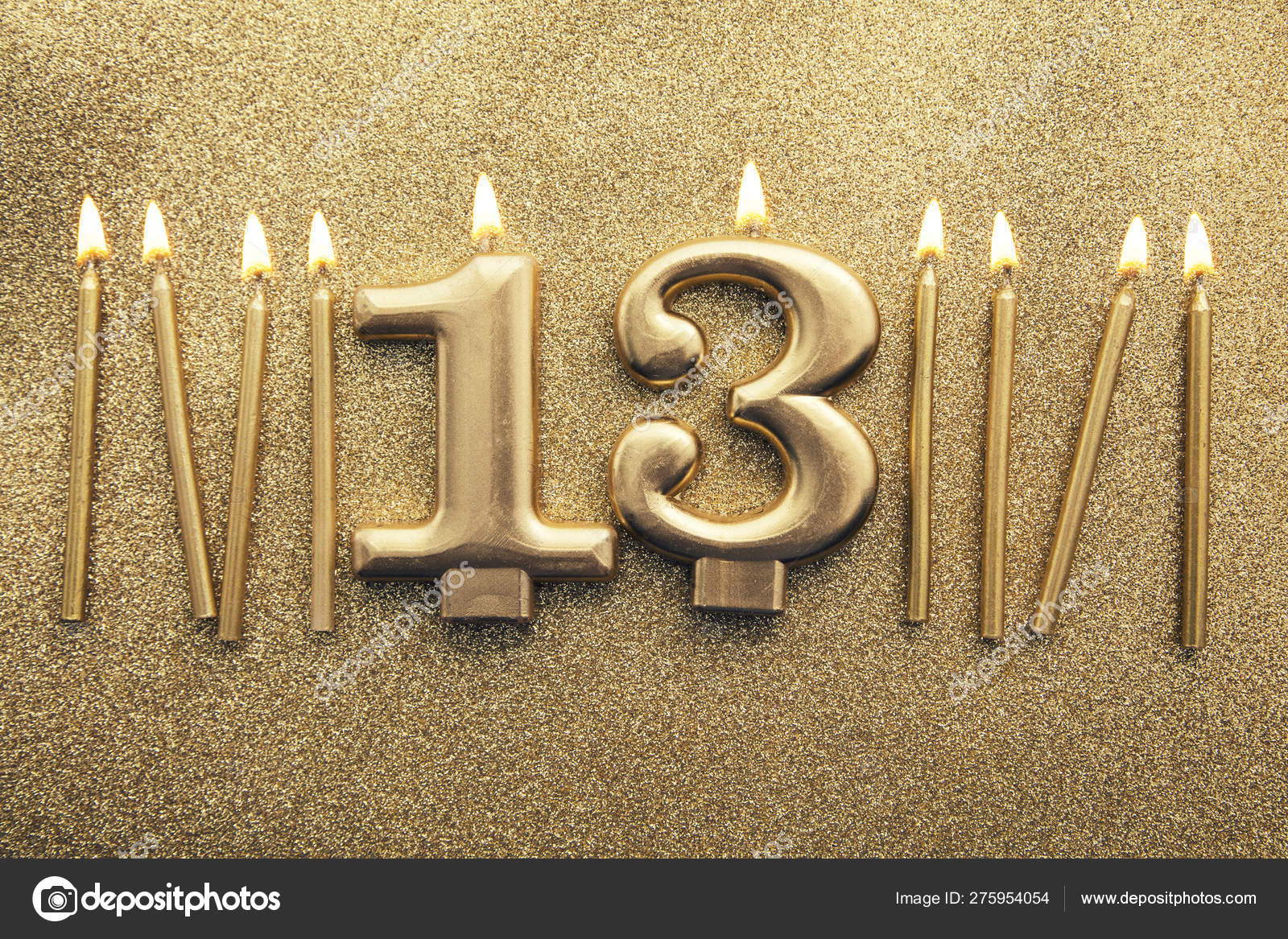Number 13 gold celebration candle on a glitter background Stock Photo