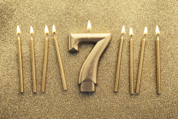 Numero 7 candela celebrazione d'oro su uno sfondo glitter — Foto Stock