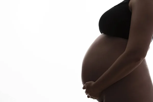 Wanita hamil dengan bayi bertabrakan siluet pada latar belakang putih — Stok Foto
