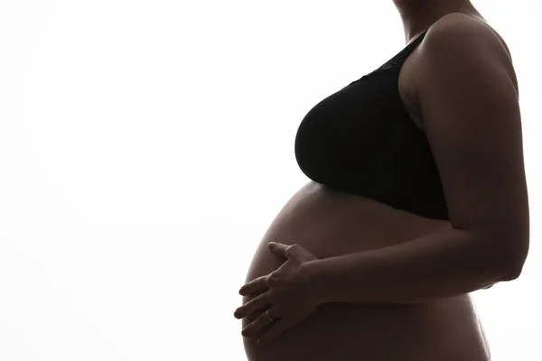 Těhotná žena s dětskou bouli siluetnou na bílém pozadí — Stock fotografie