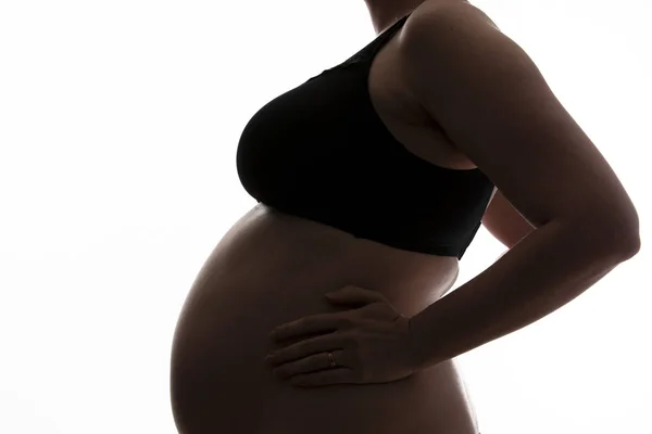 Pregnant woman with a baby bump silhouetted on a white background — Stock Photo, Image