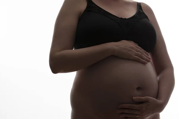 Donna incinta con un pancione sagomato su uno sfondo bianco — Foto Stock