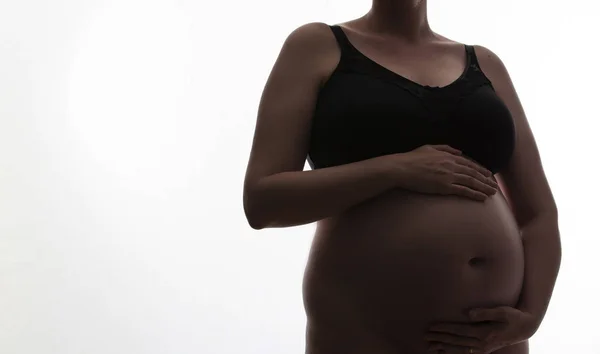 Femeie gravidă cu un copil cucui siluetă pe un fundal alb — Fotografie, imagine de stoc