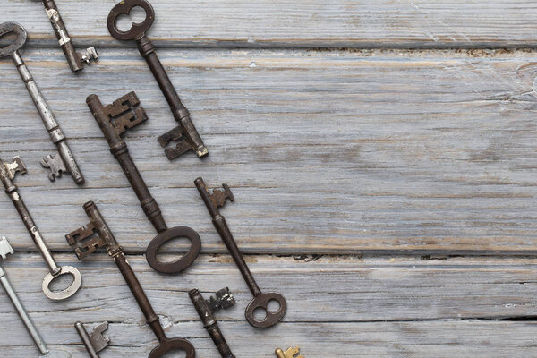 Vintage old fashioned keys on a rustic wooden background. Security concept