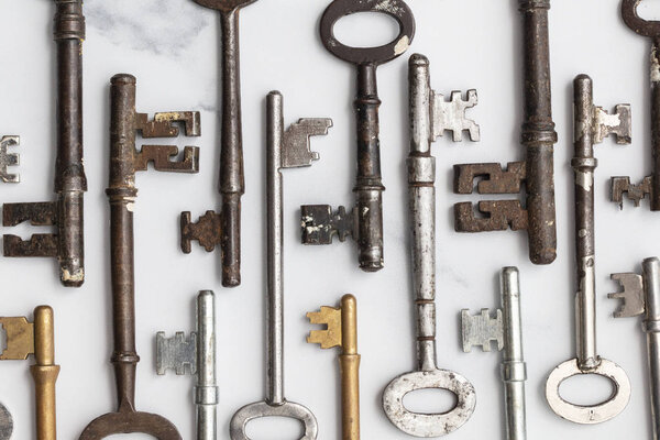 Large set of vintage keys on a plain background. Safety and security concept