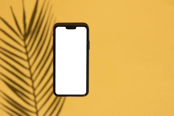 Modello di smartphone tropicale. smartphone bianco con ombra esotica palma — Foto Stock