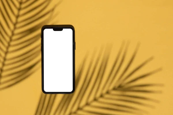 Modello di smartphone tropicale. smartphone bianco con ombra esotica palma — Foto Stock